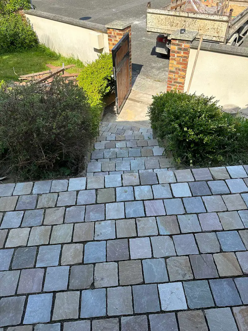 Allée en pavés de pierre bordée de végétation