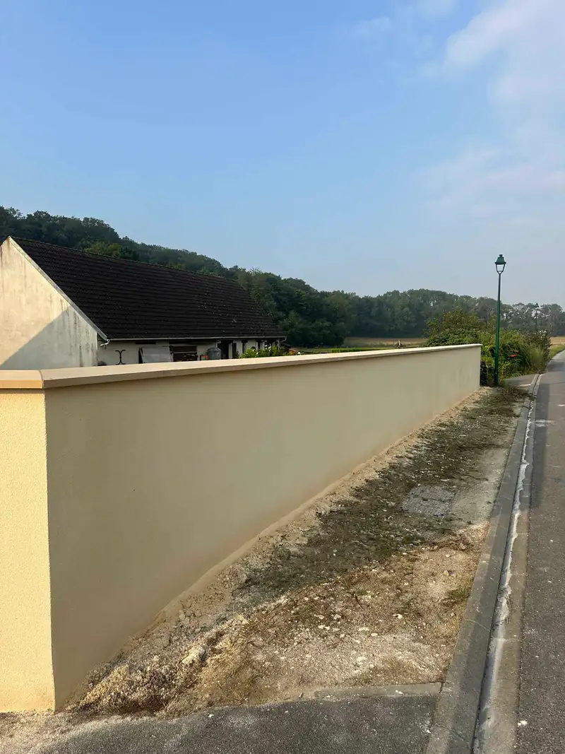 Mur de clôture enduit le long d'une route