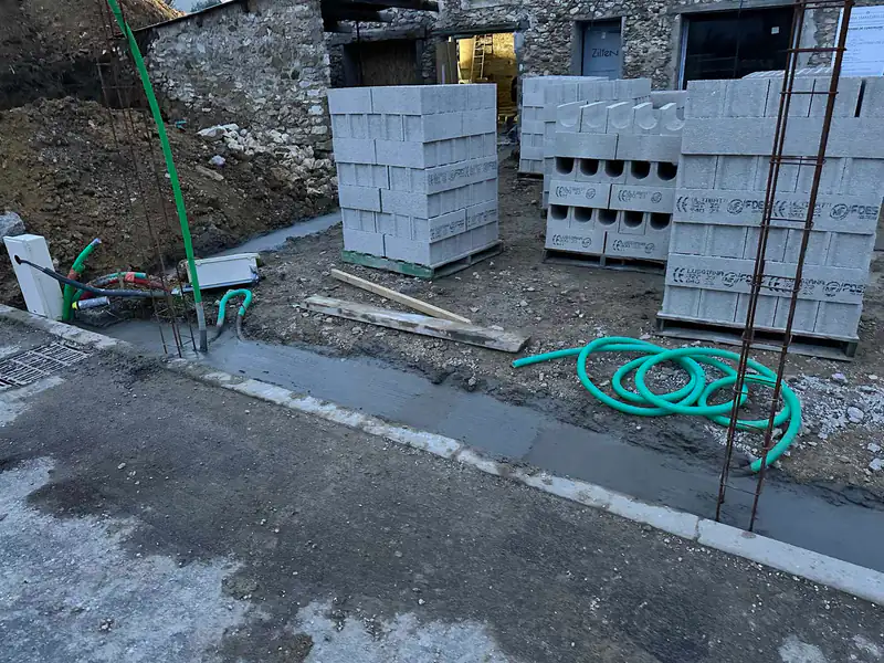 Fondation d'un mur de clôture et palettes de blocs béton