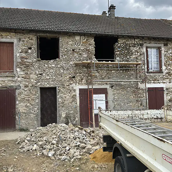 Maison en pierre en début de chantier, gravats et camion benne