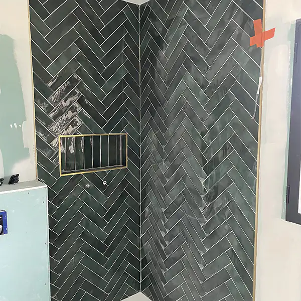 Faïence verte en chevrons dans une douche
